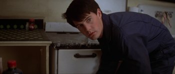 Movie still from “Blue Velvet” (1986), directed by David Lynch – A man leaning on a counter in a kitchen; Close Up shot, Low angle