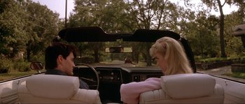 Movie still from “Blue Velvet” (1986), directed by David Lynch – A man and a woman sitting in the driver's seat of a car; Medium shot, Over the shoulder angle