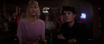 Movie still from “Blue Velvet” (1986), directed by David Lynch – A man and a woman sitting at a table in front of other people; Close Up shot, Low angle