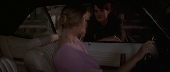 Movie still from “Blue Velvet” (1986), directed by David Lynch – A man and a woman looking at each other in the backseat of a car; Medium shot, Over the shoulder angle