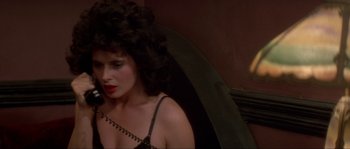 Movie still from “Blue Velvet” (1986), directed by David Lynch – A woman in a black top holding an umbrella; Close Up shot, High angle
