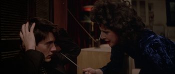 Movie still from “Blue Velvet” (1986), directed by David Lynch – A woman holding an umbrella over a man's face; Close Up shot, Over the shoulder angle