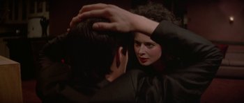 A woman touching a man's hair in front of a mirror