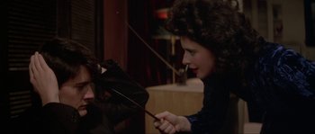 Movie still from “Blue Velvet” (1986), directed by David Lynch – A woman holding an open umbrella and looking at the camera; Close Up shot, Over the shoulder angle