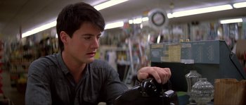 Movie still from “Blue Velvet” (1986), directed by David Lynch – A man sitting at a table looking at a clock; Close Up shot, Low angle