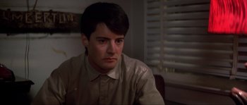 Movie still from “Blue Velvet” (1986), directed by David Lynch – A man sitting at a table in front of a window; Close Up shot, Over the shoulder angle