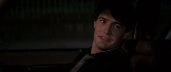 Movie still from “Blue Velvet” (1986), directed by David Lynch – A person wearing a suit and tie; Close Up shot, Over the shoulder angle