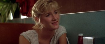 A woman sitting in a booth looking to her left