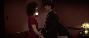Movie still from “Blue Velvet” (1986), directed by David Lynch – A man and a woman holding hands in a room; Medium shot, Over the shoulder angle