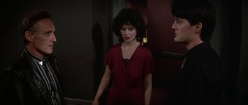 Movie still from “Blue Velvet” (1986), directed by David Lynch – A woman in a red dress standing in front of a mirror; Medium shot, Over the shoulder angle