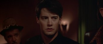 Movie still from “Blue Velvet” (1986), directed by David Lynch – A person wearing a black shirt; Close Up shot, Over the shoulder angle