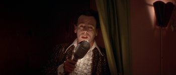 Movie still from “Blue Velvet” (1986), directed by David Lynch – A man with a microphone in his mouth; Close Up shot, Low angle