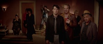 Movie still from “Blue Velvet” (1986), directed by David Lynch – A group of people standing in a living room; Medium shot, Low angle