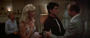 Movie still from “Blue Velvet” (1986), directed by David Lynch – A man and a woman sitting next to each other in a room; Medium shot, Over the shoulder angle