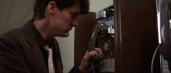 Movie still from “Blue Velvet” (1986), directed by David Lynch – A young man is looking at a pay phone; Close Up shot, Low angle