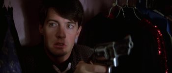 Movie still from “Blue Velvet” (1986), directed by David Lynch – A man holding a gun in a room; Close Up shot, Over the shoulder angle