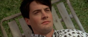 Movie still from “Blue Velvet” (1986), directed by David Lynch – A man's face with a fence in the background; Close Up shot, High angle