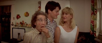 Movie still from “Blue Velvet” (1986), directed by David Lynch – Three people standing next to each other in a room; Medium shot, Over the shoulder angle