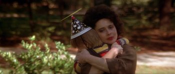 Movie still from “Blue Velvet” (1986), directed by David Lynch – A woman hugging a boy wearing a party hat; Close Up shot, Over the shoulder angle