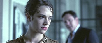 Movie still from “Boarding Gate” (2007), directed by Olivier Assayas – A man and a woman standing next to each other; Close Up shot, Over the shoulder angle