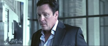 Movie still from “Boarding Gate” (2007), directed by Olivier Assayas – A person wearing a suit and tie; Close Up shot, Over the shoulder angle