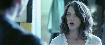Movie still from “Boarding Gate” (2007), directed by Olivier Assayas – A person looking surprised; Close Up shot, Over the shoulder angle