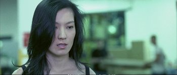 Movie still from “Boarding Gate” (2007), directed by Olivier Assayas – A person with long black hair; Close Up shot, Over the shoulder angle