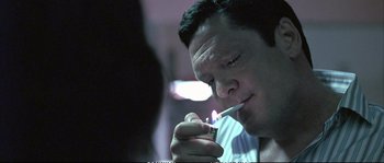 Movie still from “Boarding Gate” (2007), directed by Olivier Assayas – A person lighting a cigarette; Close Up shot, Low angle