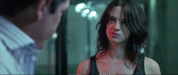 Movie still from “Boarding Gate” (2007), directed by Olivier Assayas – A woman standing in front of a man in a dark room; Close Up shot, Over the shoulder angle