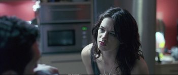 Movie still from “Boarding Gate” (2007), directed by Olivier Assayas – A woman sitting in front of an oven looking sad; Close Up shot, Over the shoulder angle