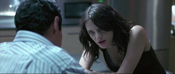 Movie still from “Boarding Gate” (2007), directed by Olivier Assayas – A woman sitting in front of a man in front of a television; Close Up shot, Over the shoulder angle