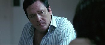 Movie still from “Boarding Gate” (2007), directed by Olivier Assayas – A person wearing a striped shirt; Close Up shot, Over the shoulder angle