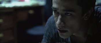 Movie still from “Boarding Gate” (2007), directed by Olivier Assayas – A young man looking into the distance while sitting down; Close Up shot, Low angle