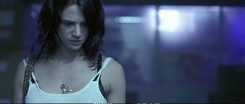 Movie still from “Boarding Gate” (2007), directed by Olivier Assayas – A woman in a white tank top looking at the camera; Close Up shot, Low angle
