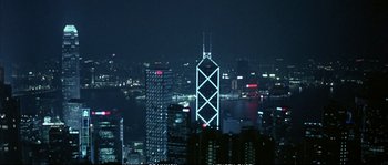 Movie still from “Boarding Gate” (2007), directed by Olivier Assayas – A view of a city skyline at night time; Extreme Wide shot, High angle