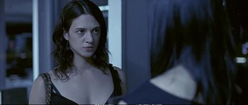 Movie still from “Boarding Gate” (2007), directed by Olivier Assayas – A woman looking at herself in the mirror; Close Up shot, Over the shoulder angle