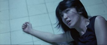 Movie still from “Boarding Gate” (2007), directed by Olivier Assayas – A young woman with long black hair is reaching out her hand; Close Up shot, Overhead angle