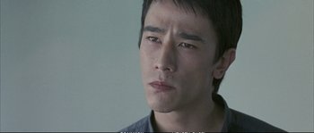 Movie still from “Boarding Gate” (2007), directed by Olivier Assayas – A person looking at the camera; Close Up shot, High angle