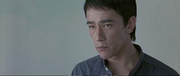 Movie still from “Boarding Gate” (2007), directed by Olivier Assayas – A person wearing a blue shirt; Close Up shot, Low angle