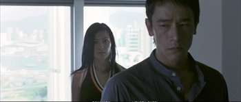 Movie still from “Boarding Gate” (2007), directed by Olivier Assayas – A man and a woman standing next to each other in front of a window; Close Up shot, Low angle