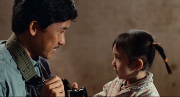 Movie still from “Boat People” (1982), directed by Ann Hui – A man and a child looking at each other; Close Up shot, Over the shoulder angle