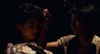 Movie still from “Boat People” (1982), directed by Ann Hui – A man and a woman in a dark room; Close Up shot, Over the shoulder angle