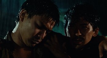 Movie still from “Boat People” (1982), directed by Ann Hui – Two men in the rain , one of whom has wet hair and one of whom has wet hair; Close Up shot, Low angle