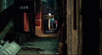 Movie still from “Boat People” (1982), directed by Ann Hui – An alley way in an asian city at night time; Extreme Wide shot, High angle