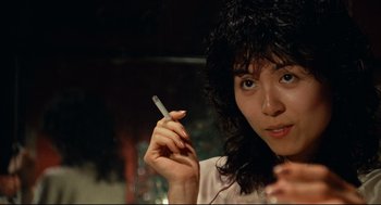 Movie still from “Boat People” (1982), directed by Ann Hui – A woman holding a cigarette in her hand; Close Up shot, Low angle