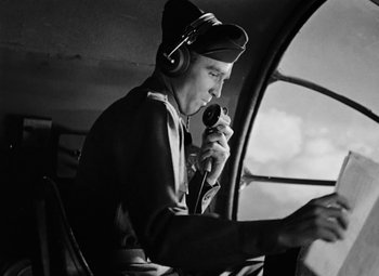 Movie still from “Bombardier” (1943), directed by Lambert Hillyer – An old photo of a man in a helicopter; Medium shot, Low angle