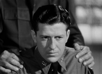 Movie still from “Bombardier” (1943), directed by Lambert Hillyer – A man with his arms around another man's shoulders; Close Up shot, Low angle