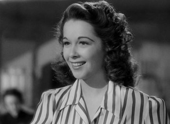 Movie still from “Bombardier” (1943), directed by Lambert Hillyer – A black - and - white photo of a woman in a striped shirt; Close Up shot, Low angle