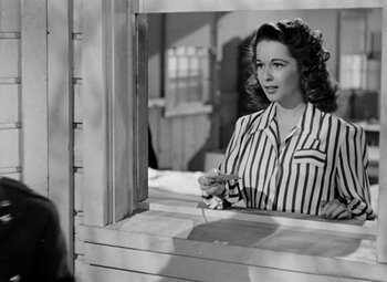 Movie still from “Bombardier” (1943), directed by Lambert Hillyer – An old photo of a woman looking in a mirror; Medium shot, Over the shoulder angle