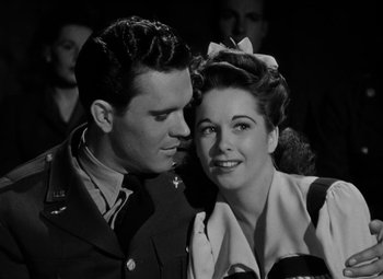 Movie still from “Bombardier” (1943), directed by Lambert Hillyer – A man and a woman in military uniforms; Close Up shot, Low angle